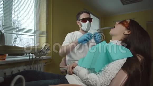 女性患者接受牙科紫外线设备治疗牙科办公室视频的预览图