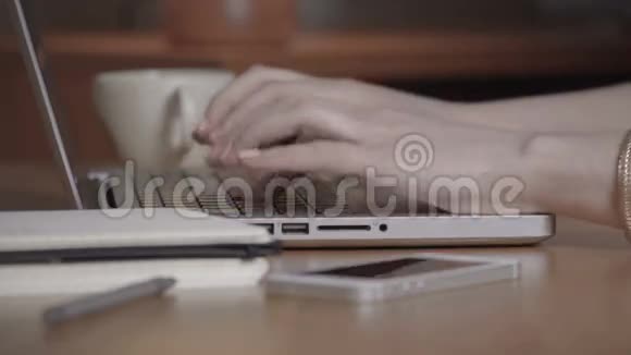 特写一只女手忙着在笔记本电脑上打字视频的预览图