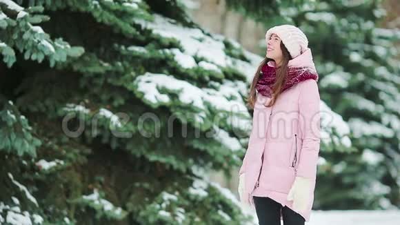 在美丽的冬日里在户外下雪的年轻女子视频的预览图