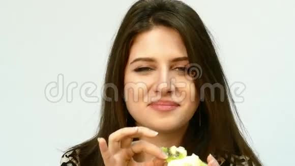 年轻美丽的白种人黑发女人吃蛋糕视频的预览图