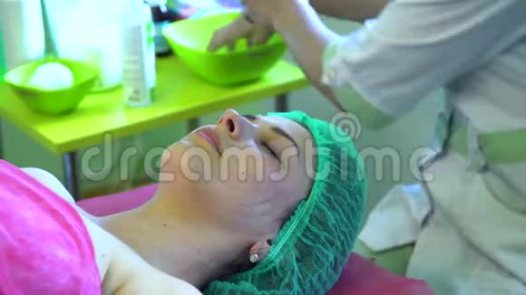 一个年轻的女孩在一个接待与美容师美容师正在准备洗脸视频的预览图