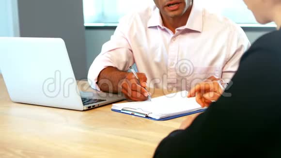 商务主管在办公桌旁讨论时握手视频的预览图