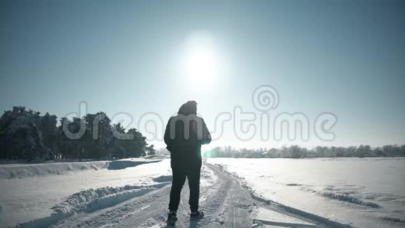 冬天背包客在雪山上散步希克在日落时走在雪地里背着背包在山上徒步旅行的人视频的预览图