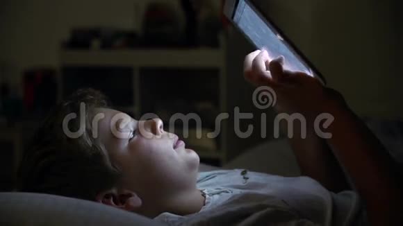 晚上在床上看数字平板的男孩视频的预览图
