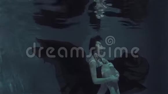 神秘的水下肖像一位穿着红色连衣裙的美丽年轻女子视频的预览图