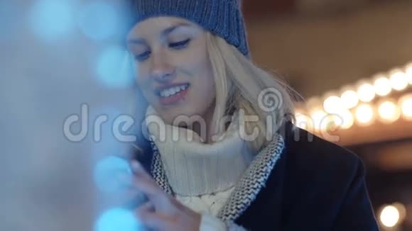 年轻女子晚上在城市里用手机视频的预览图
