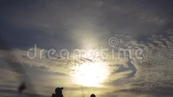 幸福的家庭游客在日落时手持剪影行走徒步旅行者团队旅游理念男女夫妇视频的预览图