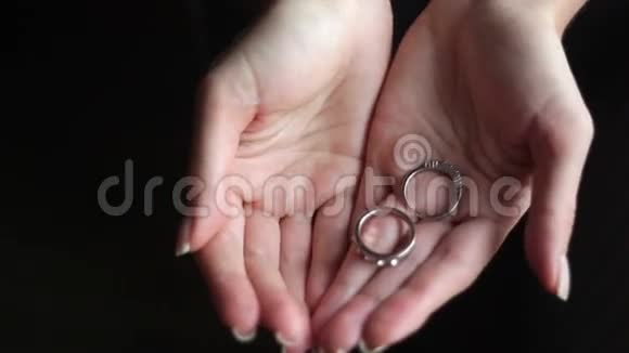 女孩的手拿着两枚戒指视频的预览图