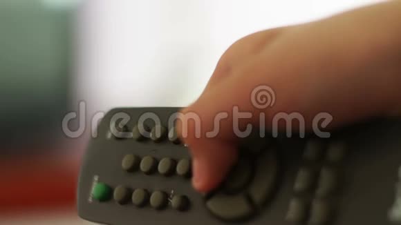 近距离拍摄一只雄性手握着电视遥控器和更换电视频道视频的预览图