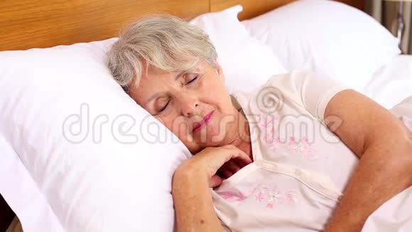 一位在床上醒来的老妇人视频的预览图