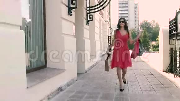 快乐的年轻女子购物后走在街上视频的预览图