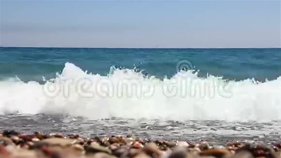 美丽的卵石海滩上海浪的背景视频的预览图