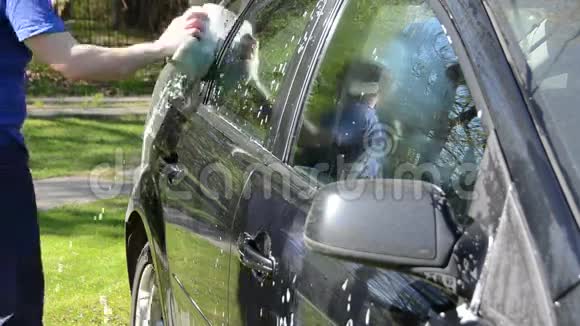 年轻人用海绵手动清洗车视频的预览图