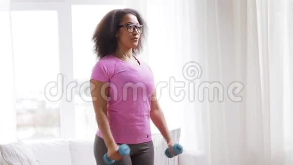 非洲妇女在家用哑铃锻炼身体视频的预览图