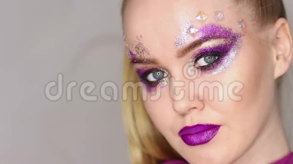 化妆紫色化妆和五颜六色的明亮指甲美少女特写肖像视频的预览图