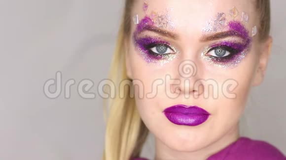 化妆紫色化妆和五颜六色的明亮指甲美少女特写肖像视频的预览图