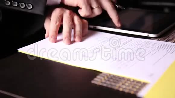 坐在办公桌前的商人签署了一份与个人电脑平板电脑比较的法案一个男人的特写和一个喷泉视频的预览图