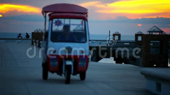 日落时分高尔夫车在码头上行驶还有一对夫妇视频的预览图