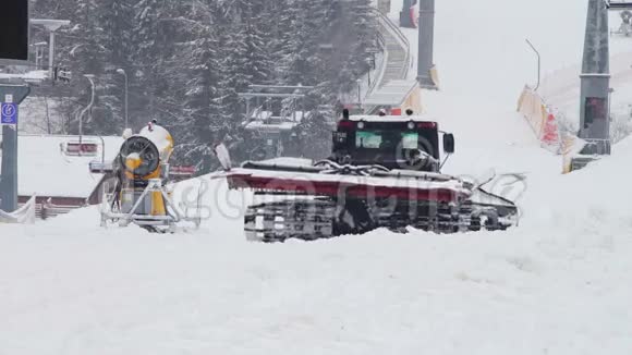 雪猫在滑雪场的山坡上工作视频的预览图