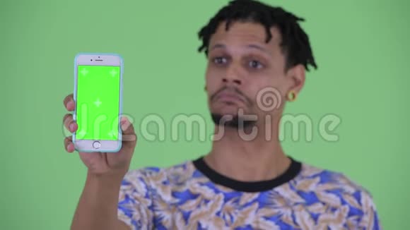 一位年轻英俊的年轻非洲男人展示电话视频的预览图