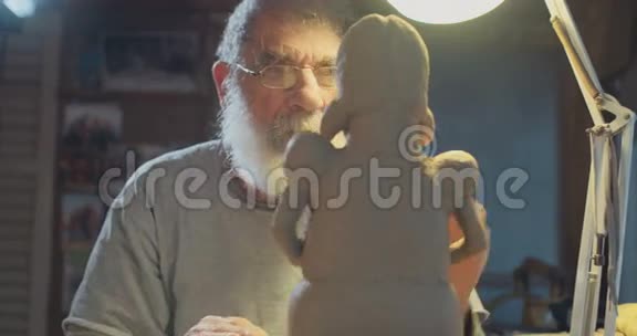 在他工作室里做泥塑的老艺术家视频的预览图
