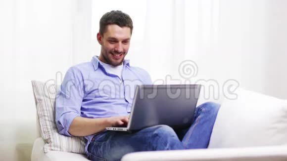 一个在家拿着笔记本电脑工作的微笑男人视频的预览图