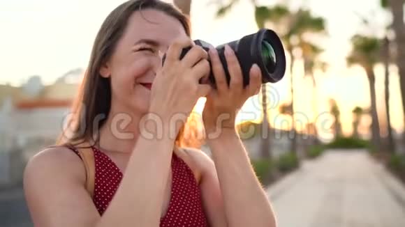 摄影女游客在日落时分用相机在美丽的热带风景中拍照视频的预览图