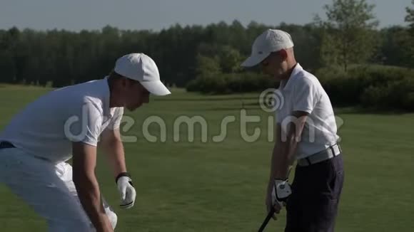 快乐的男人和他的儿子在夏日的完美高尔夫球场上行走视频的预览图
