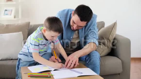 爸爸和小儿子在家里画蜡笔视频的预览图