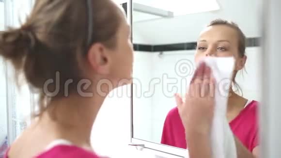 年轻女子在擦镜子视频的预览图