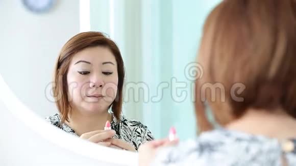 亚洲女人在卧室里化妆和看镜子视频的预览图