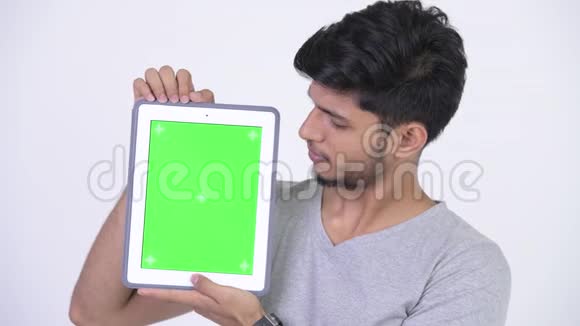年轻的长着胡子的印度男人展示数字平板电脑视频的预览图