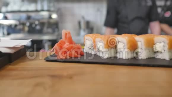 特写服务员把寿司放在餐厅的桌子上视频的预览图