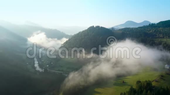 从山顶的云层中飞过高耸的山峰美妙的早晨日出自然景观视频的预览图