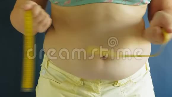 蓝色背景下的胖女人腹部特写视频的预览图