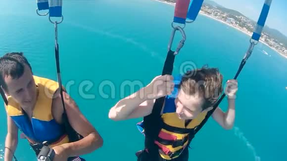 人和男孩滑翔伞和滑翔伞在海上降落伞上飞行的生活方式极限运动第一人称视频的预览图