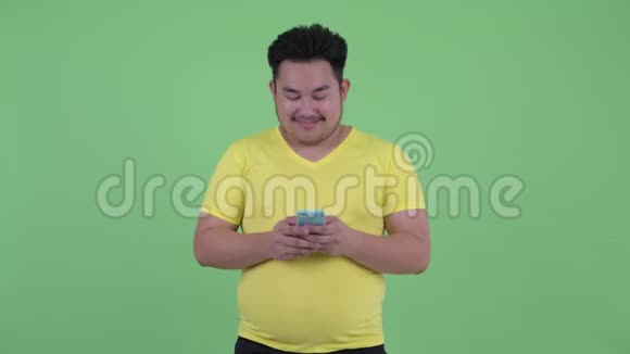 快乐年轻体重超重的亚洲男人在打电话视频的预览图