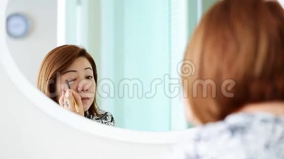 亚洲女人在卧室里化妆和看镜子视频的预览图