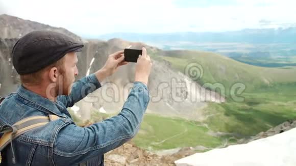 强壮的徒步旅行者在山顶用智能手机拍照奇妙的黎明视频的预览图