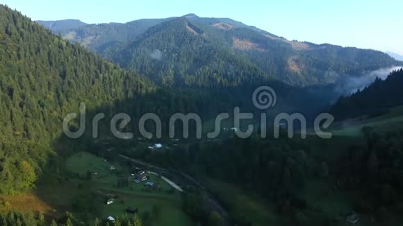 从山顶的云层中飞过高耸的山峰美妙的早晨日出自然景观视频的预览图