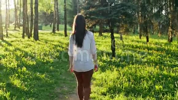 日落时分在森林里散步的女人慢动作视频的预览图