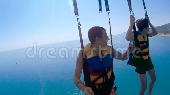 滑翔伞和滑翔伞的生活方式人类和海洋男孩正在海上乘降落伞飞行极限运动视频的预览图