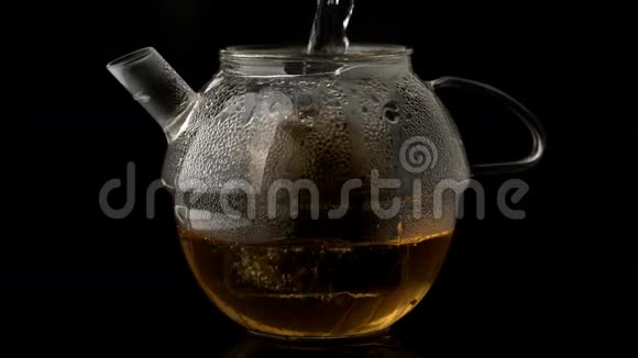 水倒在玻璃茶壶上倒在松茶上视频的预览图