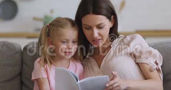 幸福的家庭妈妈和小女儿在家看书视频的预览图