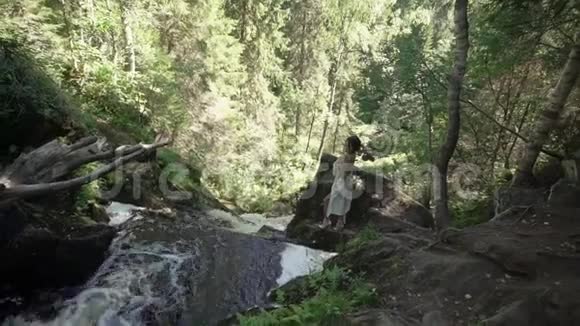 年轻女子在瀑布附近脱衣服视频的预览图