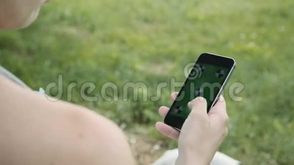 在公园使用手机的孕妇视频的预览图