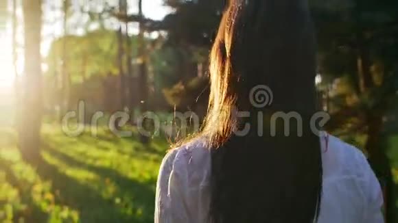 日落时分在森林里散步的女人慢动作视频的预览图