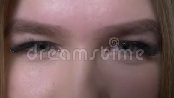 年轻漂亮的白种人女性面部特写镜头可爱的眼睛看着镜头背景与黑色隔离视频的预览图