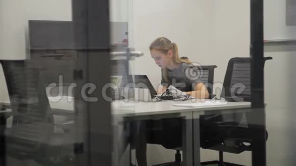 女雇员正在现代办公室用笔记本电脑办公视频的预览图