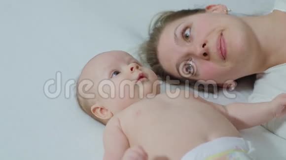 母亲和婴儿在床上拥抱视频的预览图